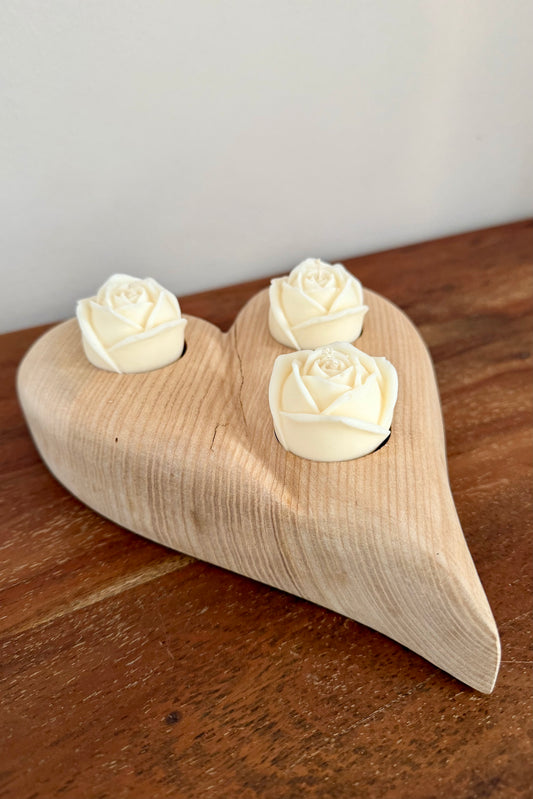 Herz aus geschliffenem Eichenholz liegend mit Designkerzen 1602