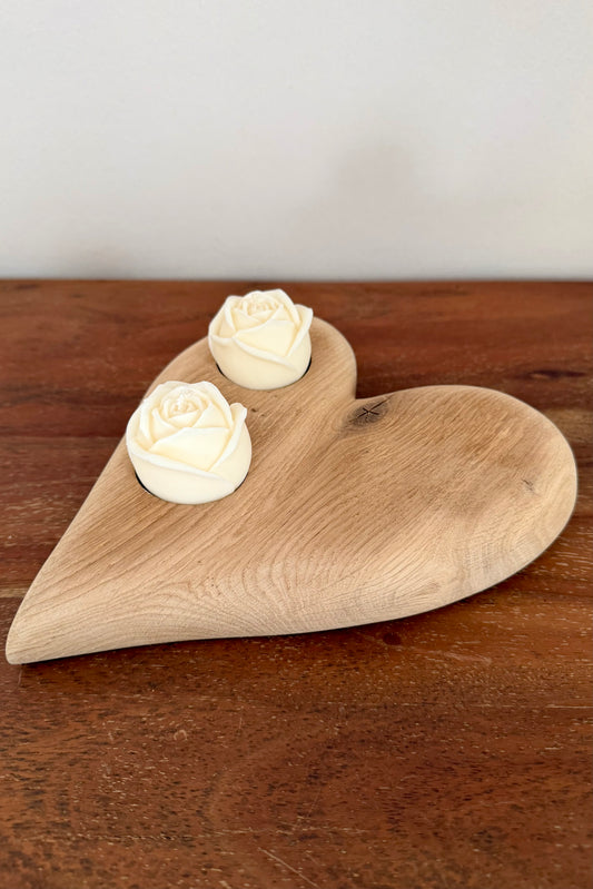 Herz aus geschliffenem Eichenholz liegend mit Designkerzen 1601