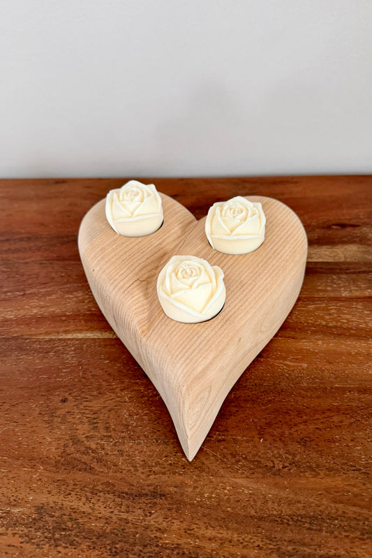 Herz aus geschliffenem Eichenholz liegend mit Designkerzen 1602