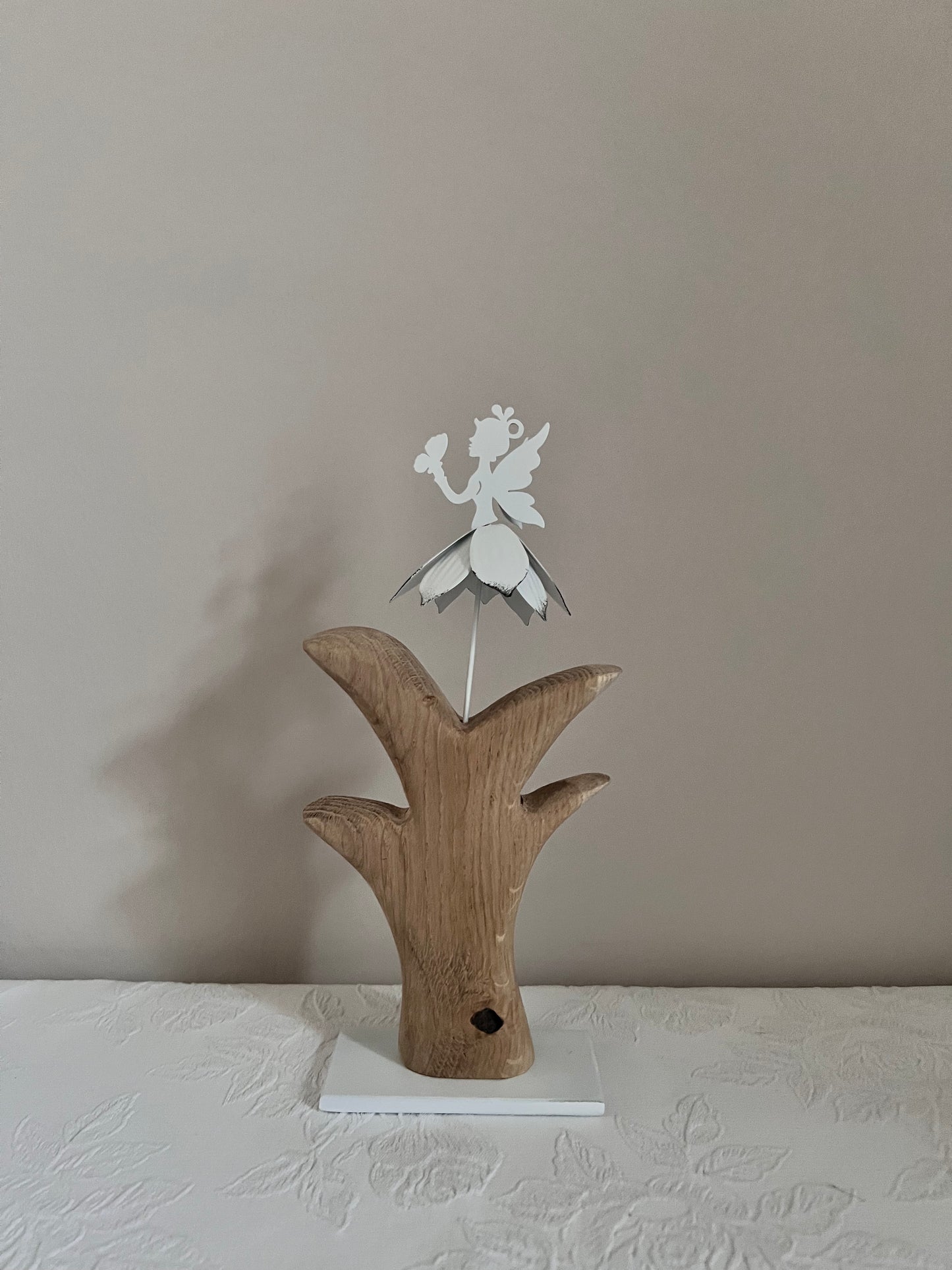 Metallblumenmädchen weiß auf geschliffenem Eichenholz 0890